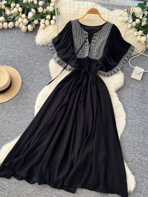 Black embroidered V-neck bohemian maxi dress with flutter sleeves and tie waist.