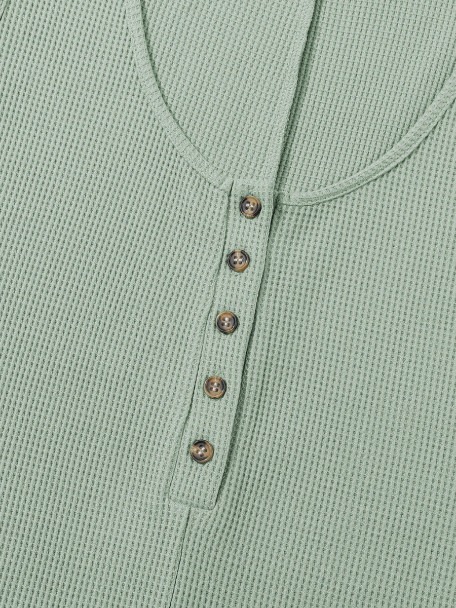 Sage green waffle knit button-down romper with round neckline and brown buttons.