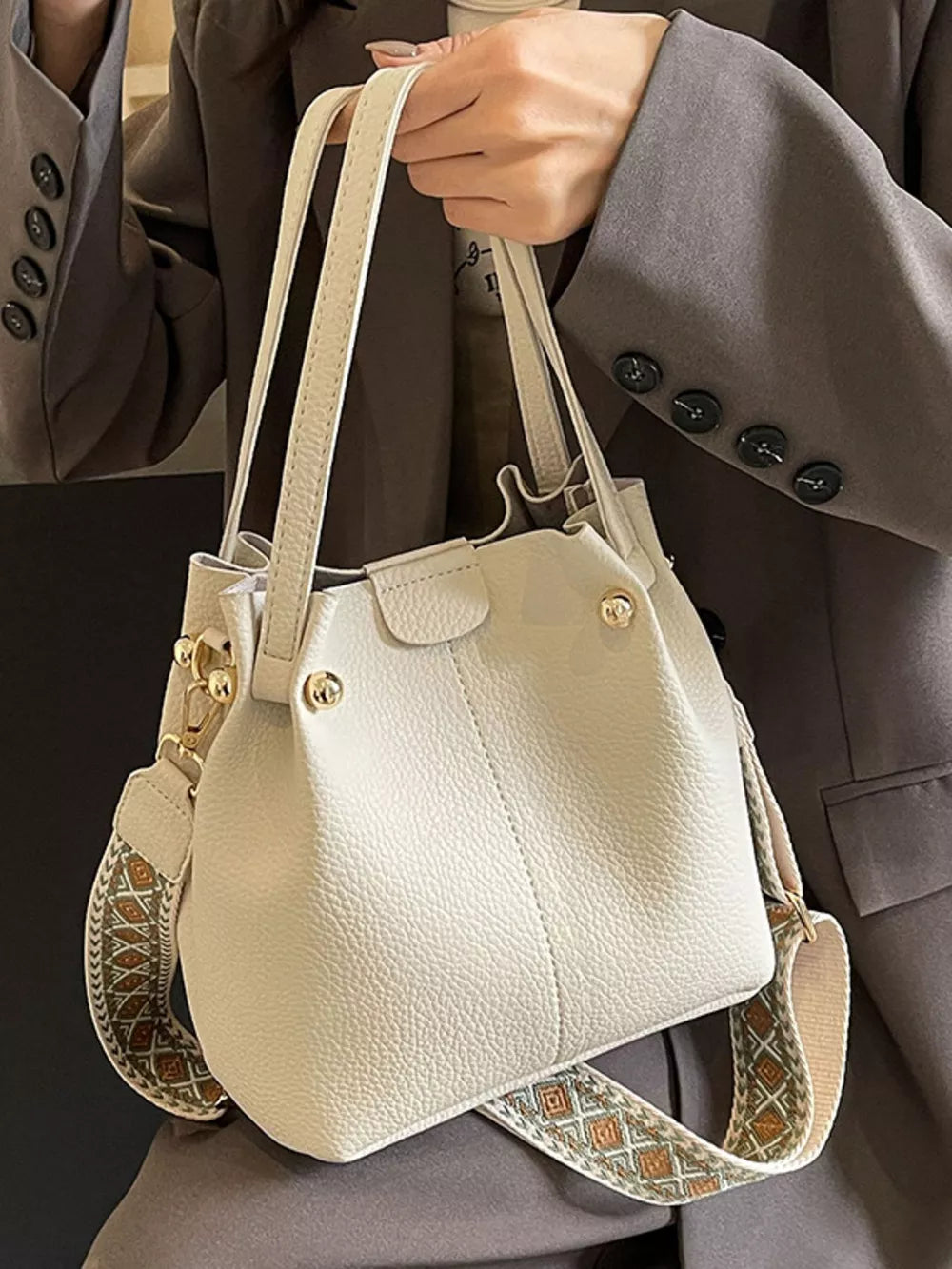 Textured crossbody bag in Rice White with a unique patterned strap and top handles.