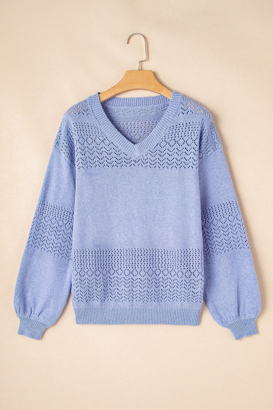 Light blue perforated knit V-neck pullover sweater with balloon sleeves and textured detail.