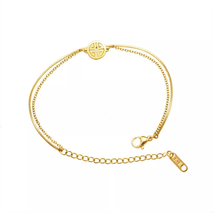 Gold double layered titanium steel bracelet with circular charm and lobster clasp.