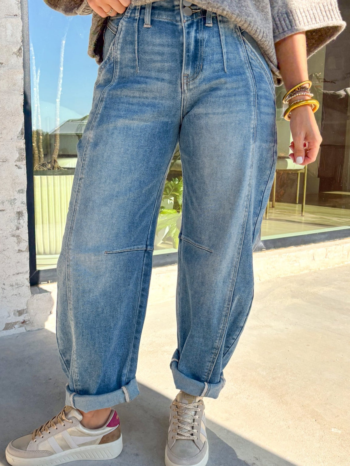 High-waisted light wash denim barrel jeans with cuffed hems and paneled details.
