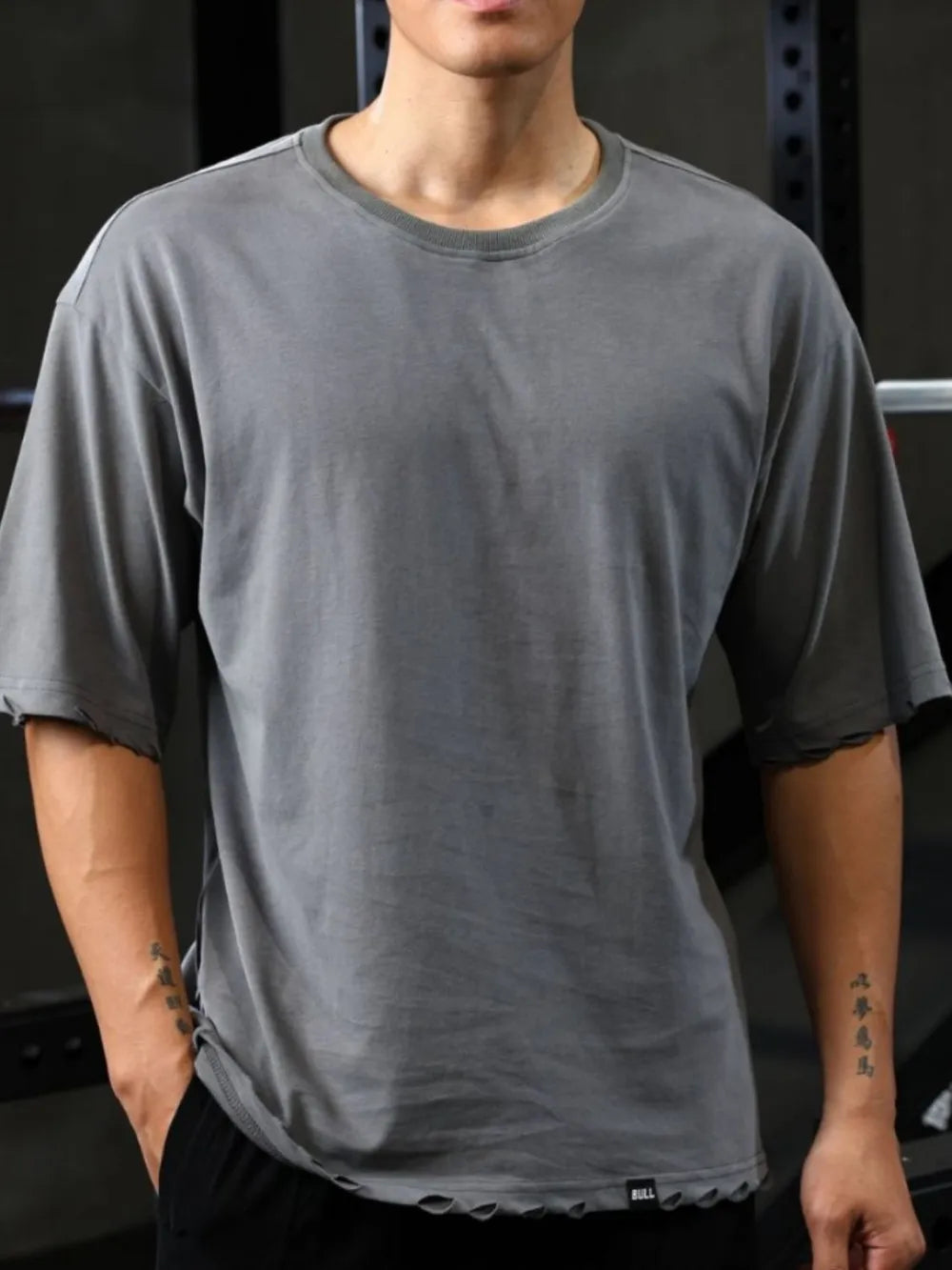 Distressed oversized gray t-shirt with raw edges and crew neck.