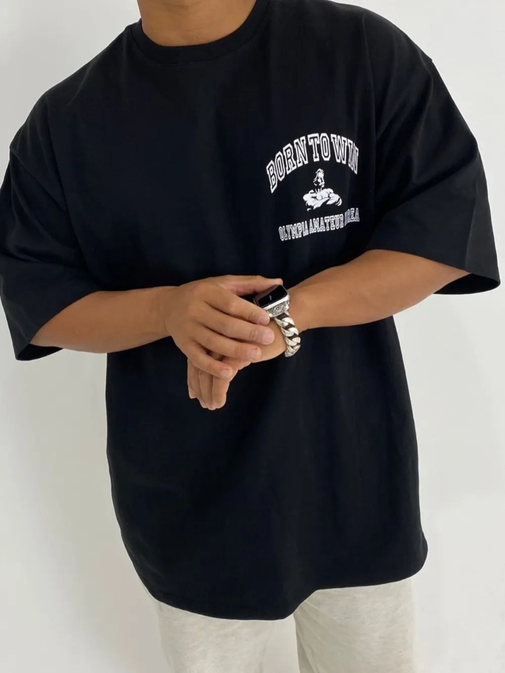 Black oversized tee with "Born to Win" graphic and bodybuilding illustration.