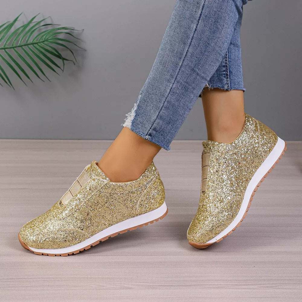 Gold glitter slip-on flats with round toe and elastic side panels.