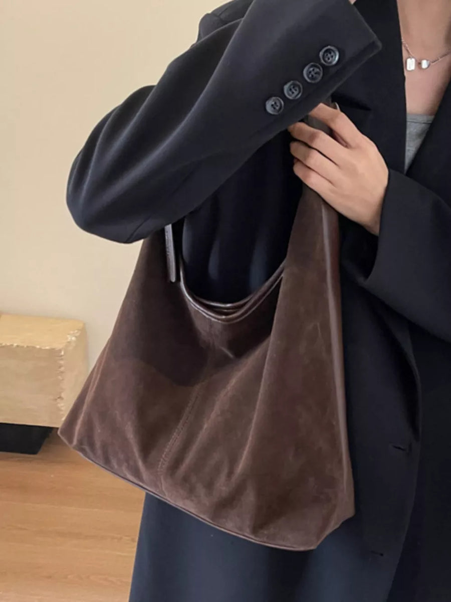 Brown plush corduroy hobo shoulder bag with a slouchy silhouette and contrast trim.