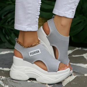 Fashion-forward gray knit open-toe wedge sandals with chunky white sole and gold ankle chain.
