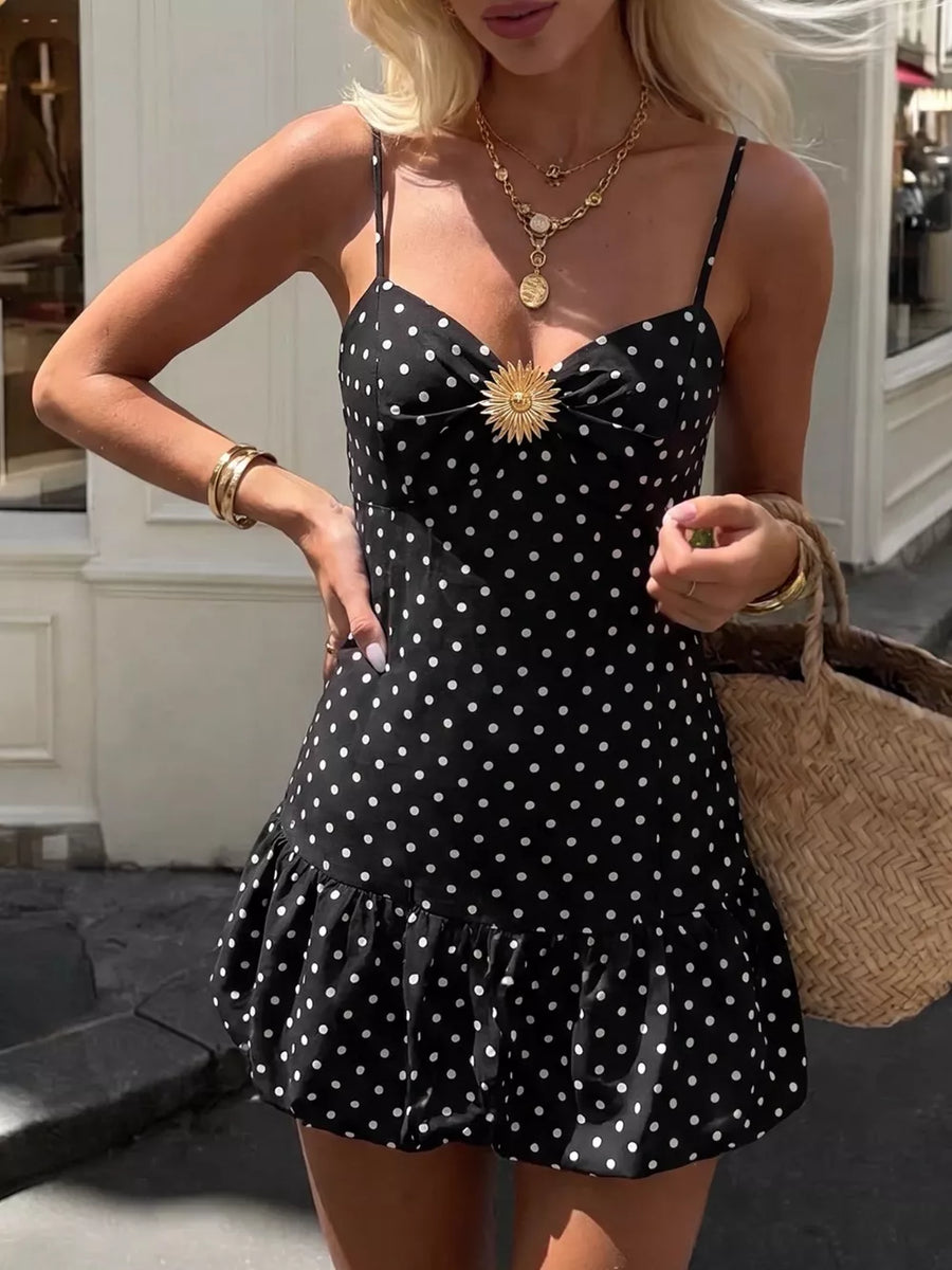 Black polka dot mini dress with spaghetti straps, sweetheart neckline, and ruffled hem.