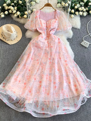 Light pink floral maxi dress with sweetheart neckline, puff sleeves, and sheer overlay.