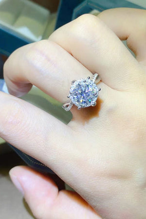 Silver halo moissanite engagement ring with a round center stone on a sterling silver band.