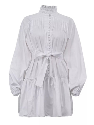 White cotton dress with ruffled neck, pintuck bodice, button front, tie waist, and tiered skirt.