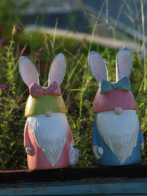 Easter bunny gnome figures in pastel blue and blush pink with bow ties and baskets.
