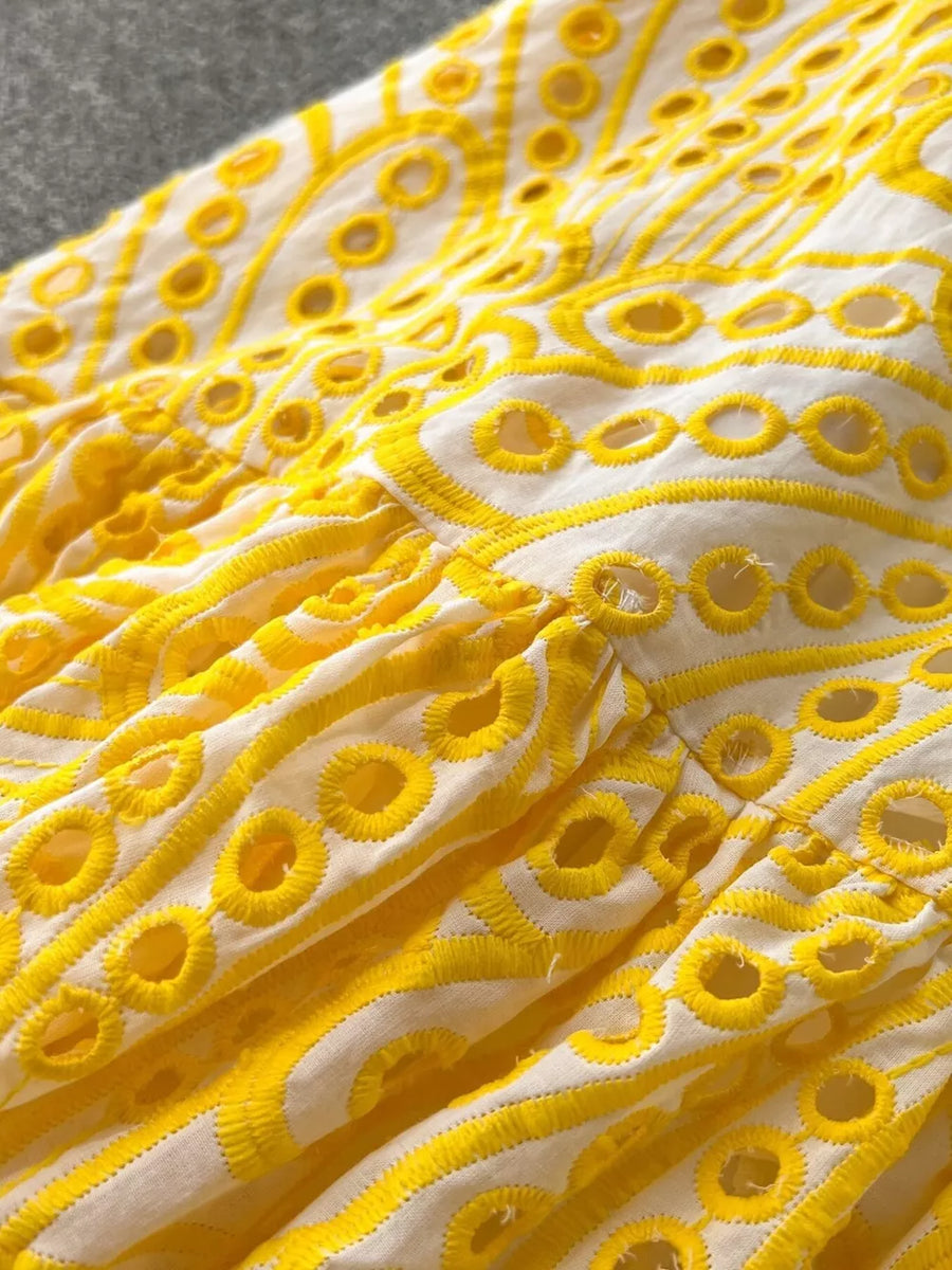 Yellow lace-embroidered tiered cami dress with eyelet details and ruffled tiers.