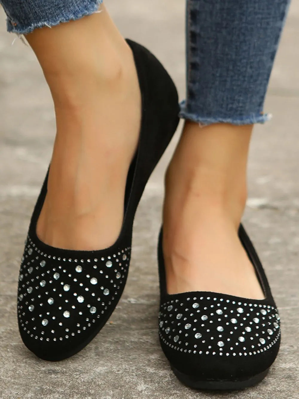 Black suede ballet flats embellished with rhinestones.