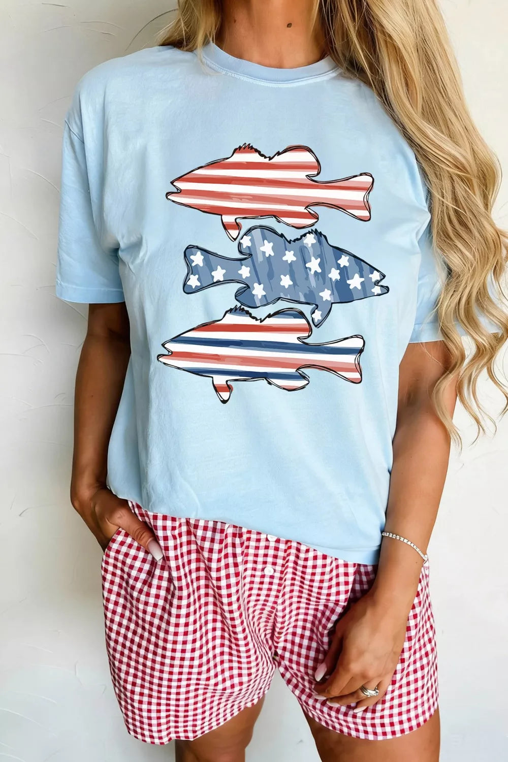 Light blue t-shirt with patriotic fish graphic, featuring American flag and stars patterns.