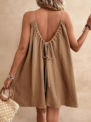 Light brown cotton gauze spaghetti strap dress with a low back tie detail.
