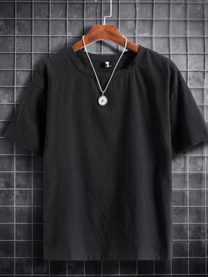 Black cotton crew neck t-shirt with short sleeves and a simple pendant necklace.