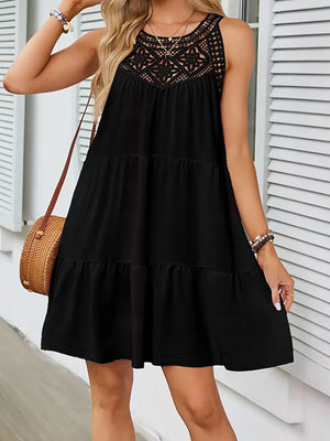 Black tiered dress with crochet lace neckline detail, sleeveless, and a ruffled hem.
