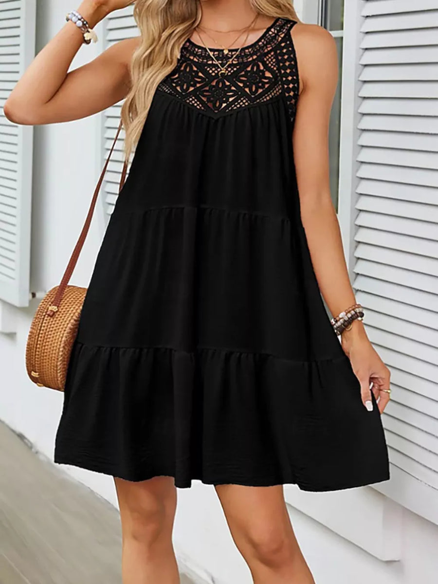 Black tiered dress with crochet lace neckline detail, sleeveless, and a ruffled hem.