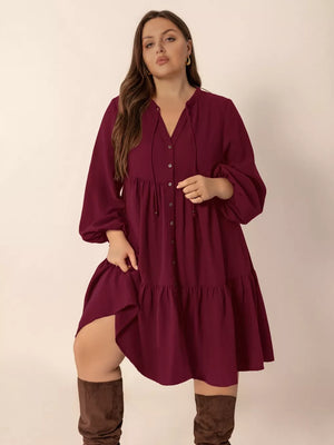 Plus-size burgundy tiered dress with balloon sleeves, V-neck, and button front.