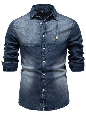 Dark wash denim button-down shirt with asymmetric pocket detail and rolled sleeves.
