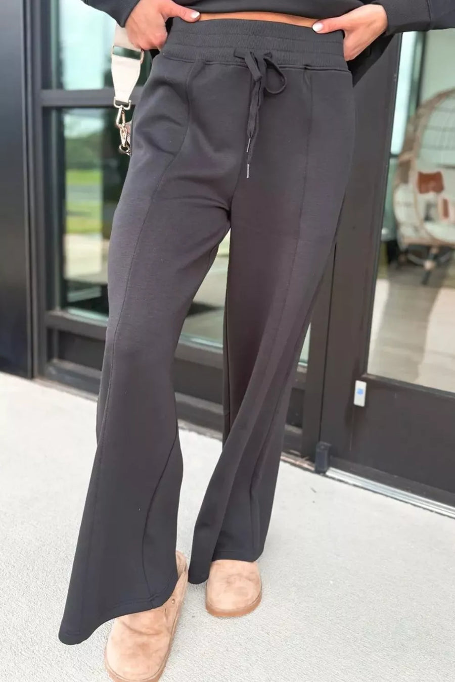 Black flared sweatpants with drawstring waist and seam detail.