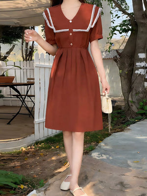 Brown short sleeve midi dress with lace-trimmed sailor collar and decorative buttons.