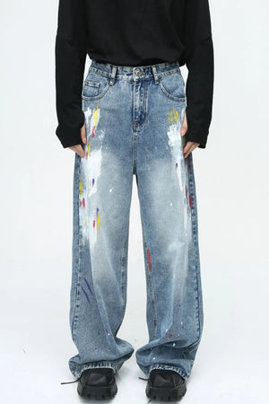 Painterly wash wide-leg denim trousers in medium blue with artistic paint splatters and a relaxed fit.
