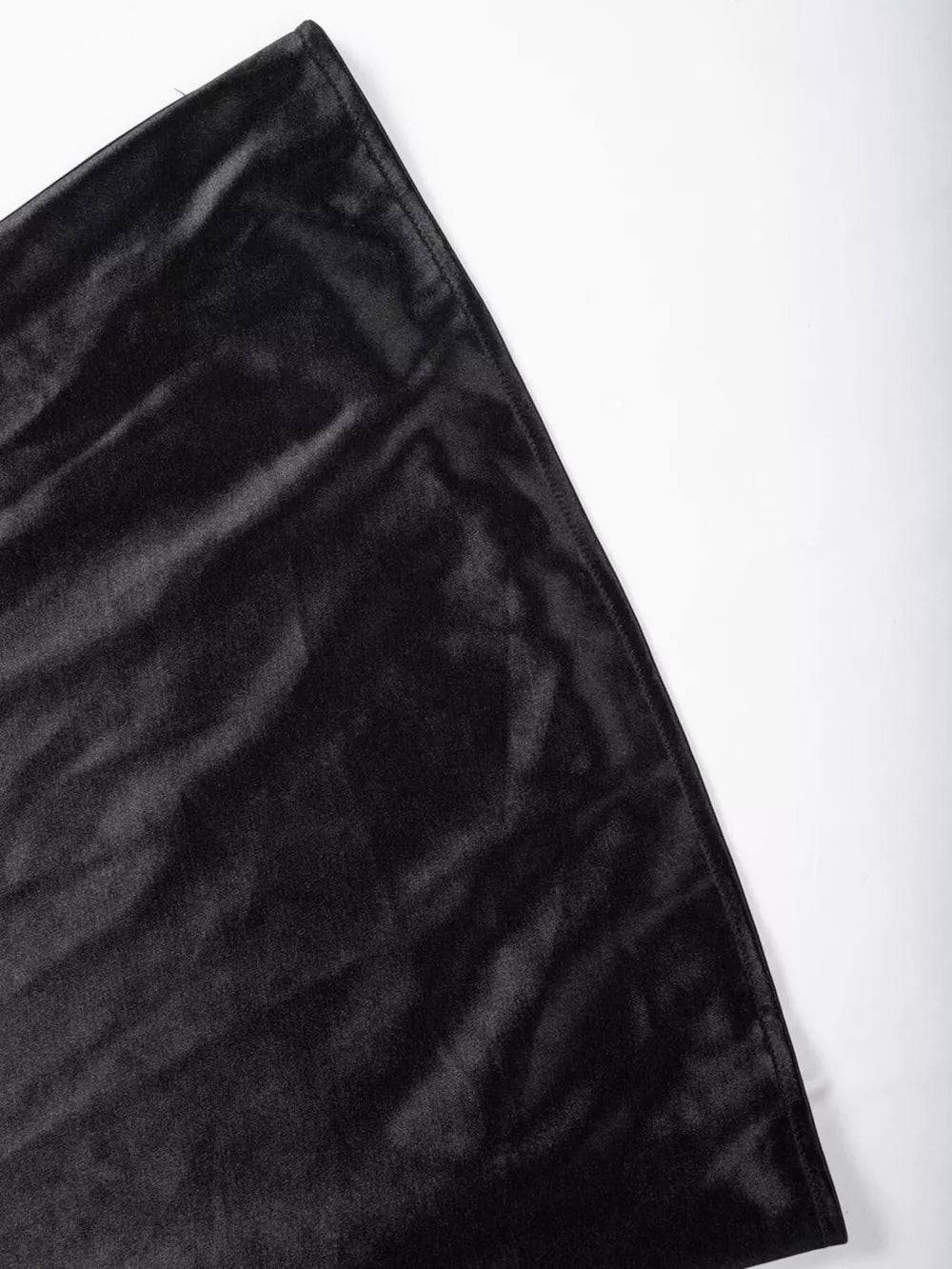 Black satin high-waisted skirt detail showing lustrous fabric texture.