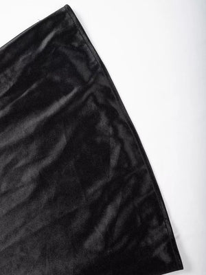 Black satin high-waisted skirt detail showing lustrous fabric texture.