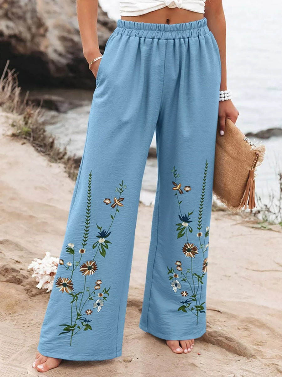 Sky blue floral wide-leg trousers with an elastic waist and embroidered flowers.
