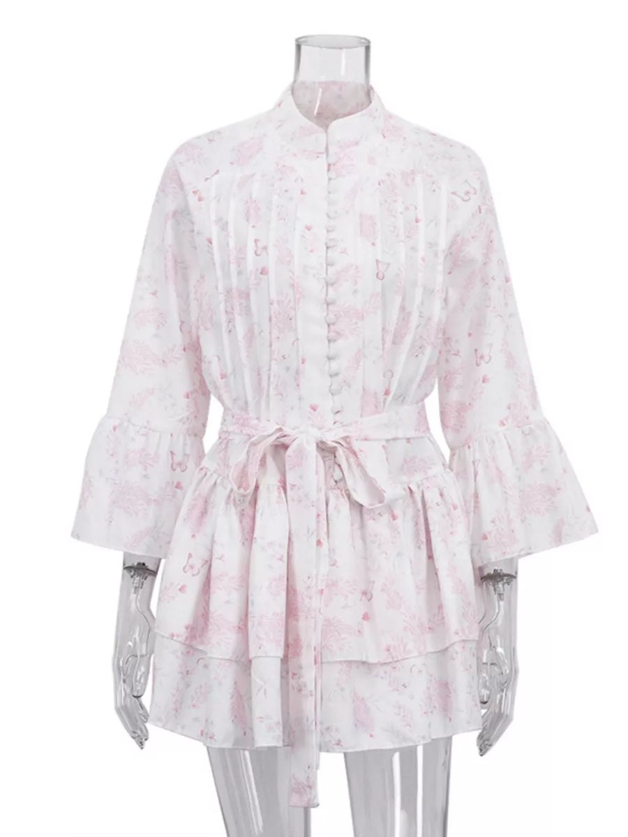 White dress with pink floral print, ruffled bell sleeves, and a tie waist.