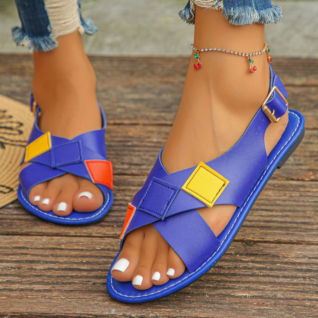 Blue criss-cross ankle strap sandals with colorful patchwork details.