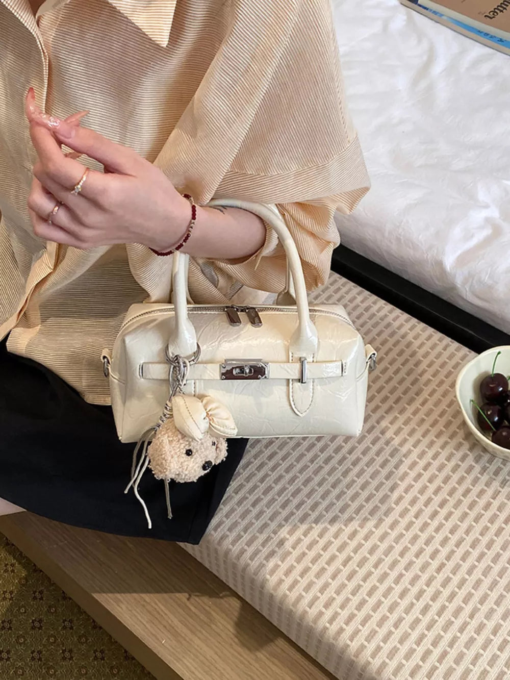 handbag in cream featuring top handle and boxy fit