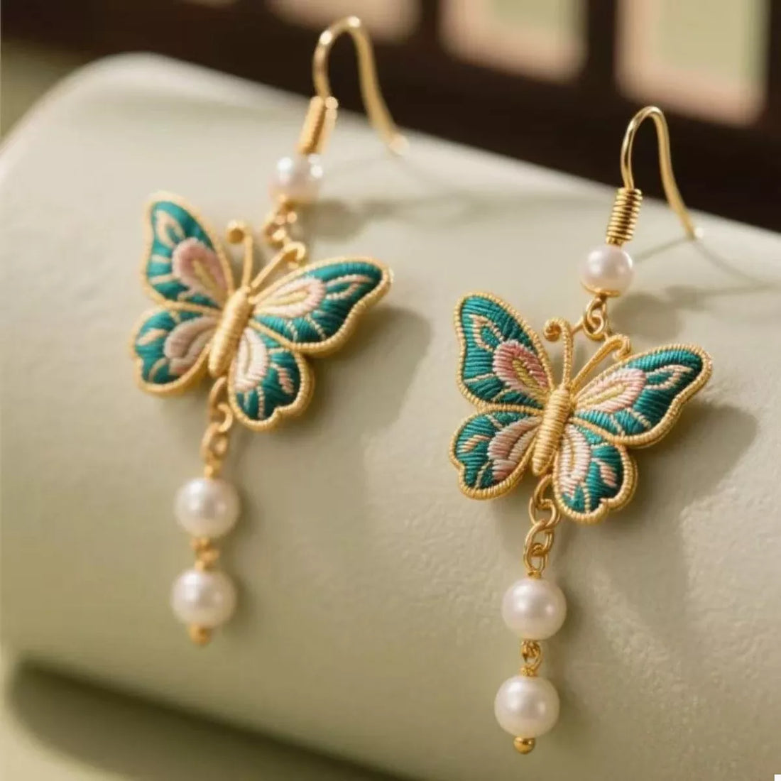 Gold butterfly dangle earrings with pearls and embroidered detail
