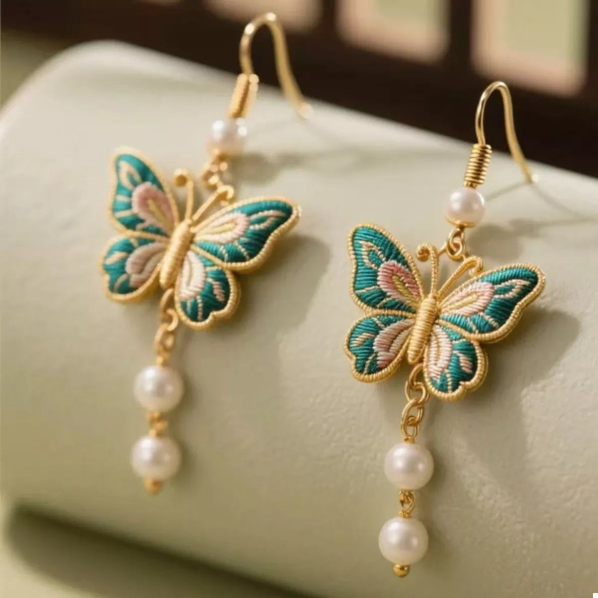 Gold butterfly dangle earrings with pearls and embroidered detail