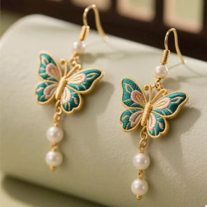 Gold butterfly dangle earrings with pearls and embroidered detail