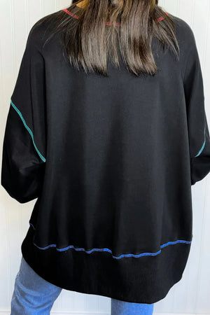 Black sweatshirt with contrast stitching on sleeves and hem, casual fall style.