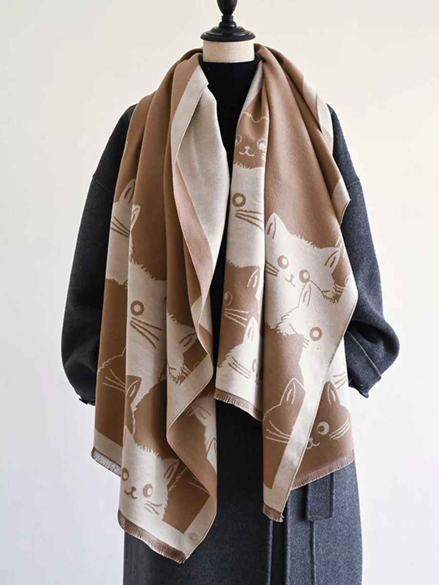 Reversible scarf in black brown with a cute cat pattern and fringed edges.
