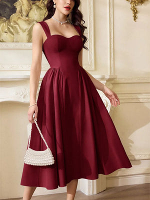 Burgundy a-line midi dress with sweetheart neckline and wide straps, shown with a pearl handbag.