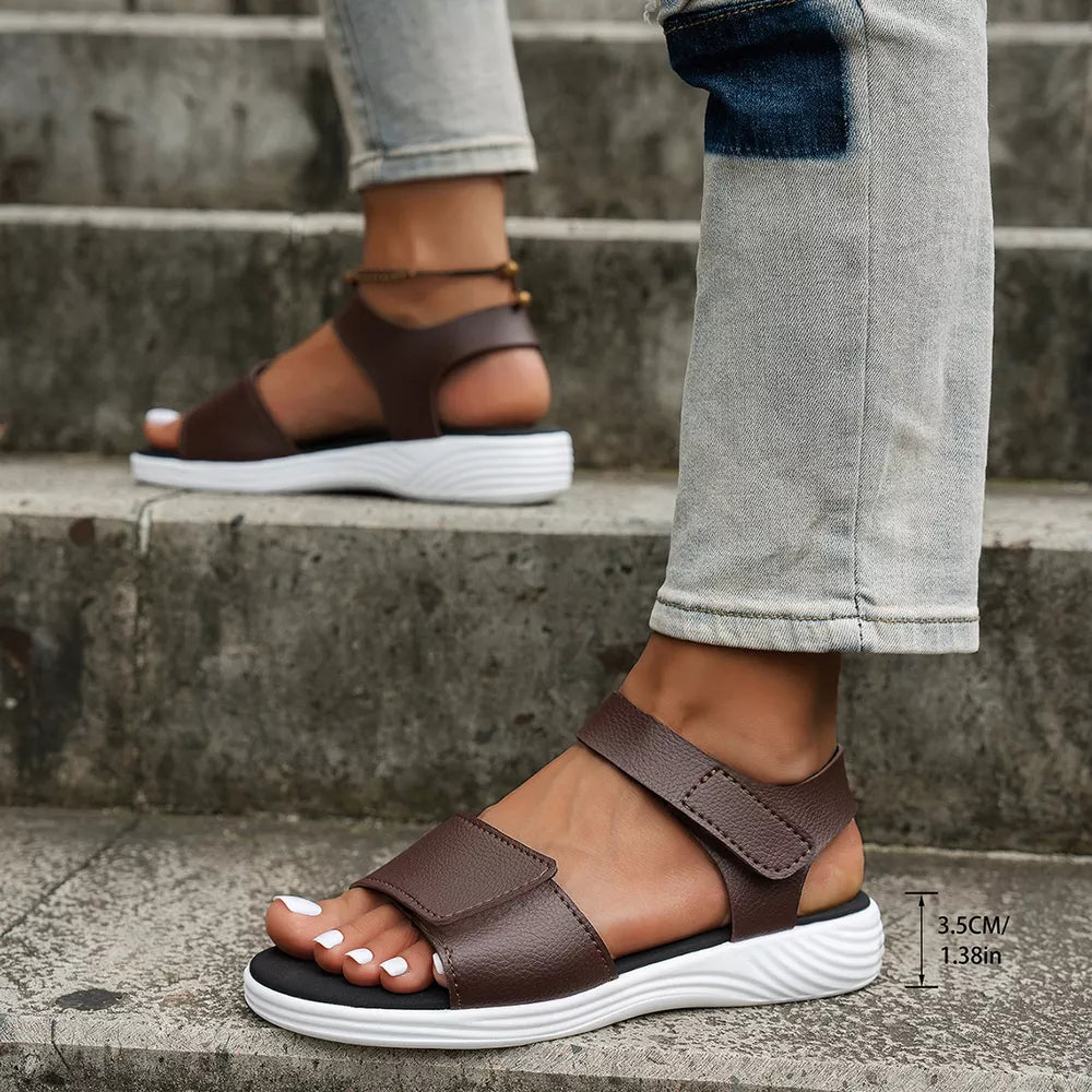 Brown adjustable open-toe platform sandals with chunky sole and white pedicure.