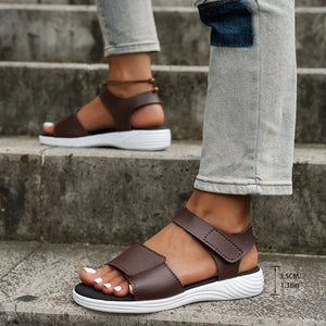 Brown adjustable open-toe platform sandals with chunky sole and white pedicure.