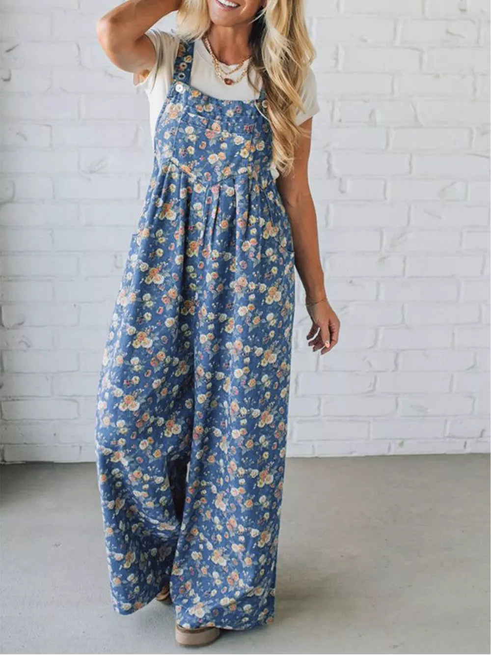 Floral denim overalls with wide legs and adjustable straps.