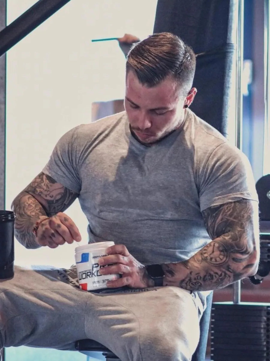 Gray crew neck tee with short sleeves, worn by a man with tattoos.