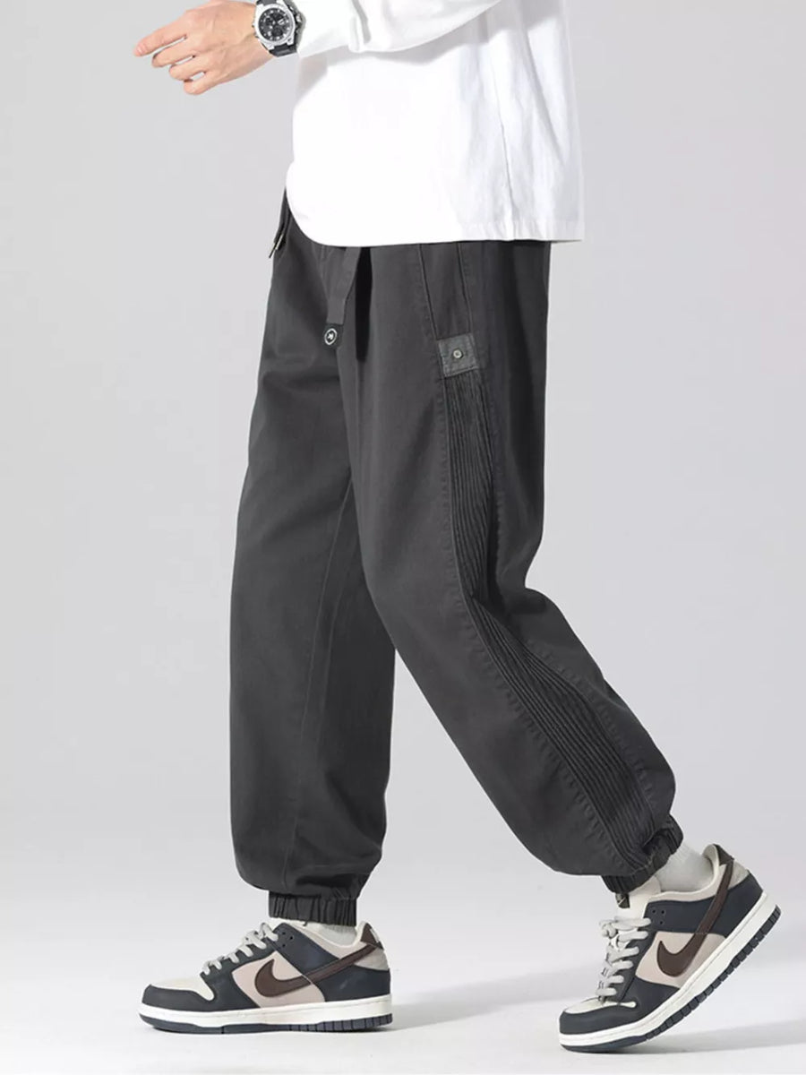 Oversized grey cargo joggers with drawstring and pleated side detail.