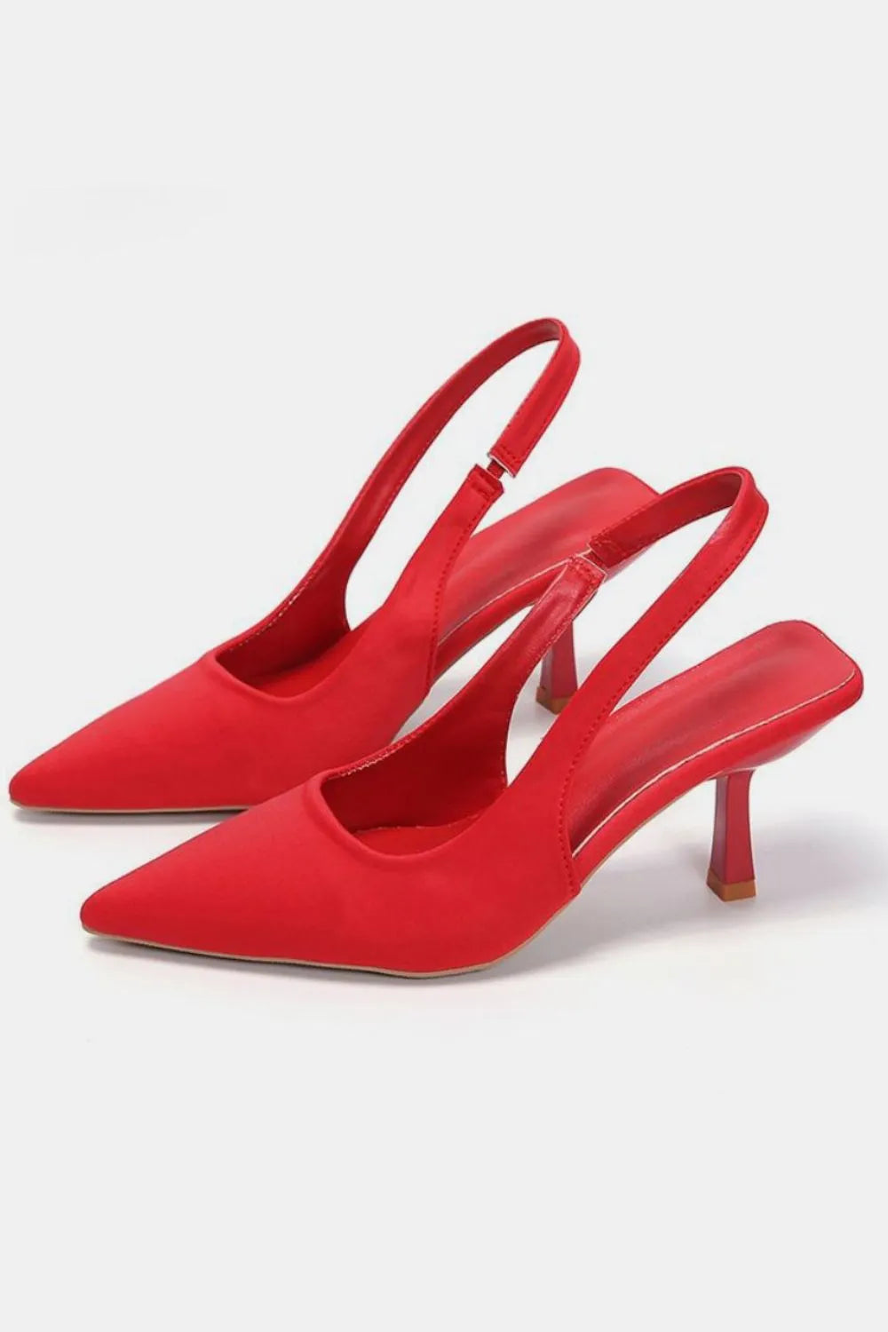 Red satin slingback pumps with a sculpted heel and pointed toe.