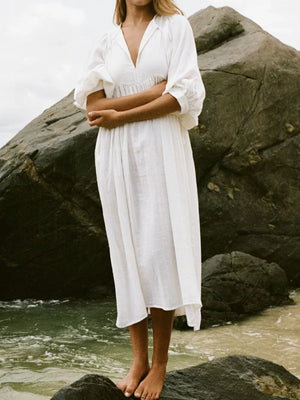 White midi dress with tie-neck, puff sleeves, and gathered waist.