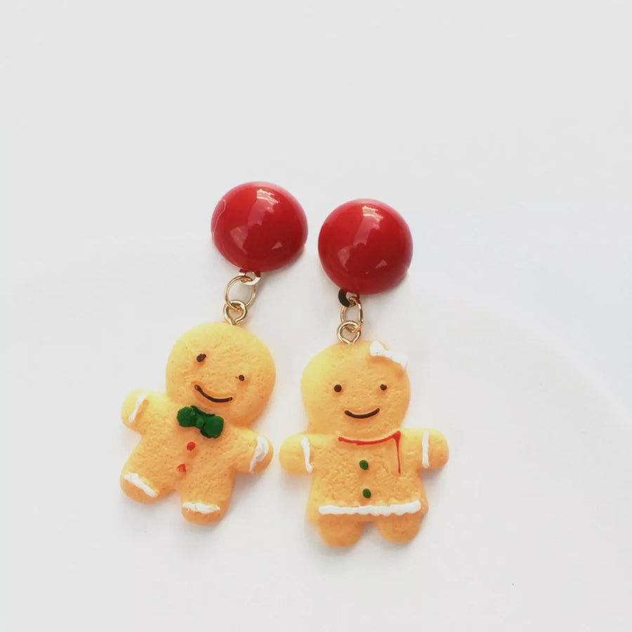 Gingerbread man holiday earrings with red bead tops and festive icing details.