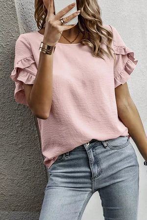 Blush pink polyester blouse with ruffle trim short sleeves and a textured finish.