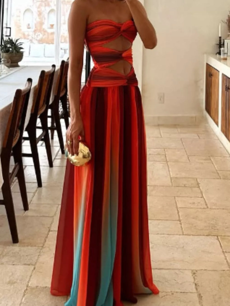 Strapless maxi dress with twisted bodice cutout and ombre stripe skirt in red, orange, and blue.